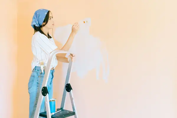 Interior painting in Wilmington: painter on a stepladder rolling a wall